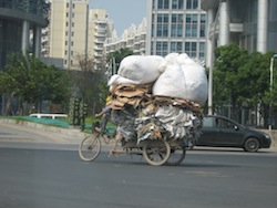 Foto di cinese in bicicletta con grande carico